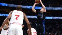 Dallas Mavericks forward Cooper Flagg (32) shoots over Houston Rockets forward Tari Eason (17) and Houston Rockets forward Kevin Durant (7) during the second half at American Airlines Center.