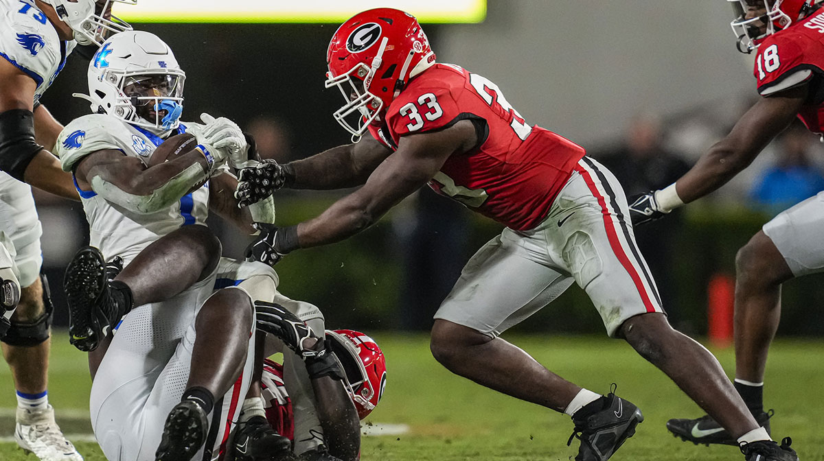 Kentucky Wildcats running back Ray Davis (1) is tackled by Georgia Bulldogs defensive lineman Jonathan Jefferson (94) and linebacker C.J. Allen (33) during the second half at Sanford Stadium.