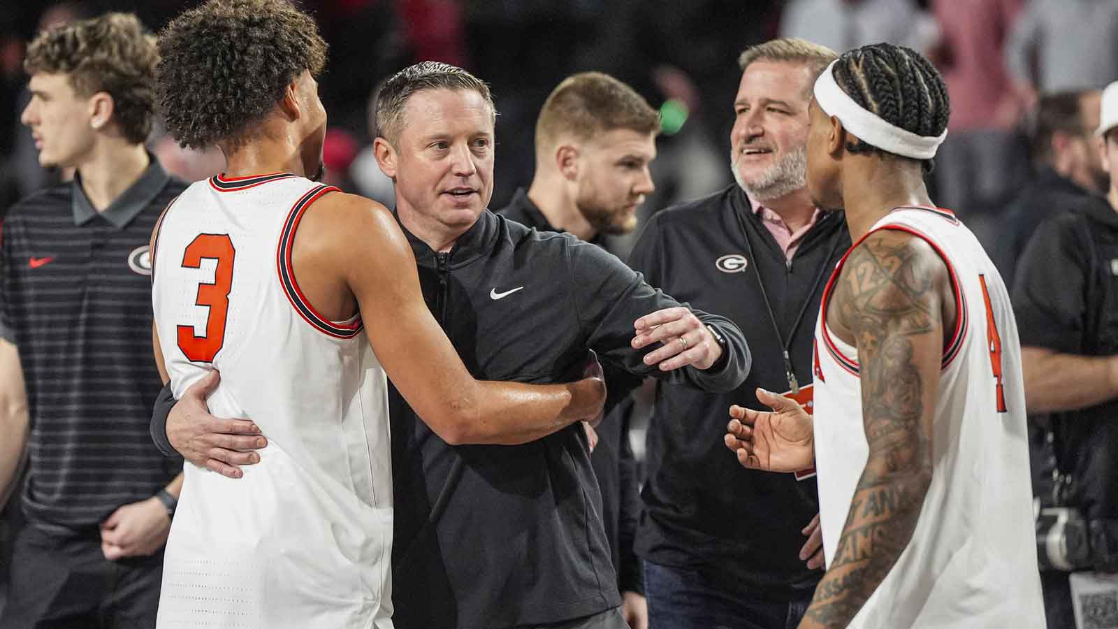 Georgia Bulldogs head coach Mike White reacts with guards Jordan Ross (3) and Marcus Millender (4) after Georgia defeated the Arkansas Razorbacks at Stegeman Coliseum. 
