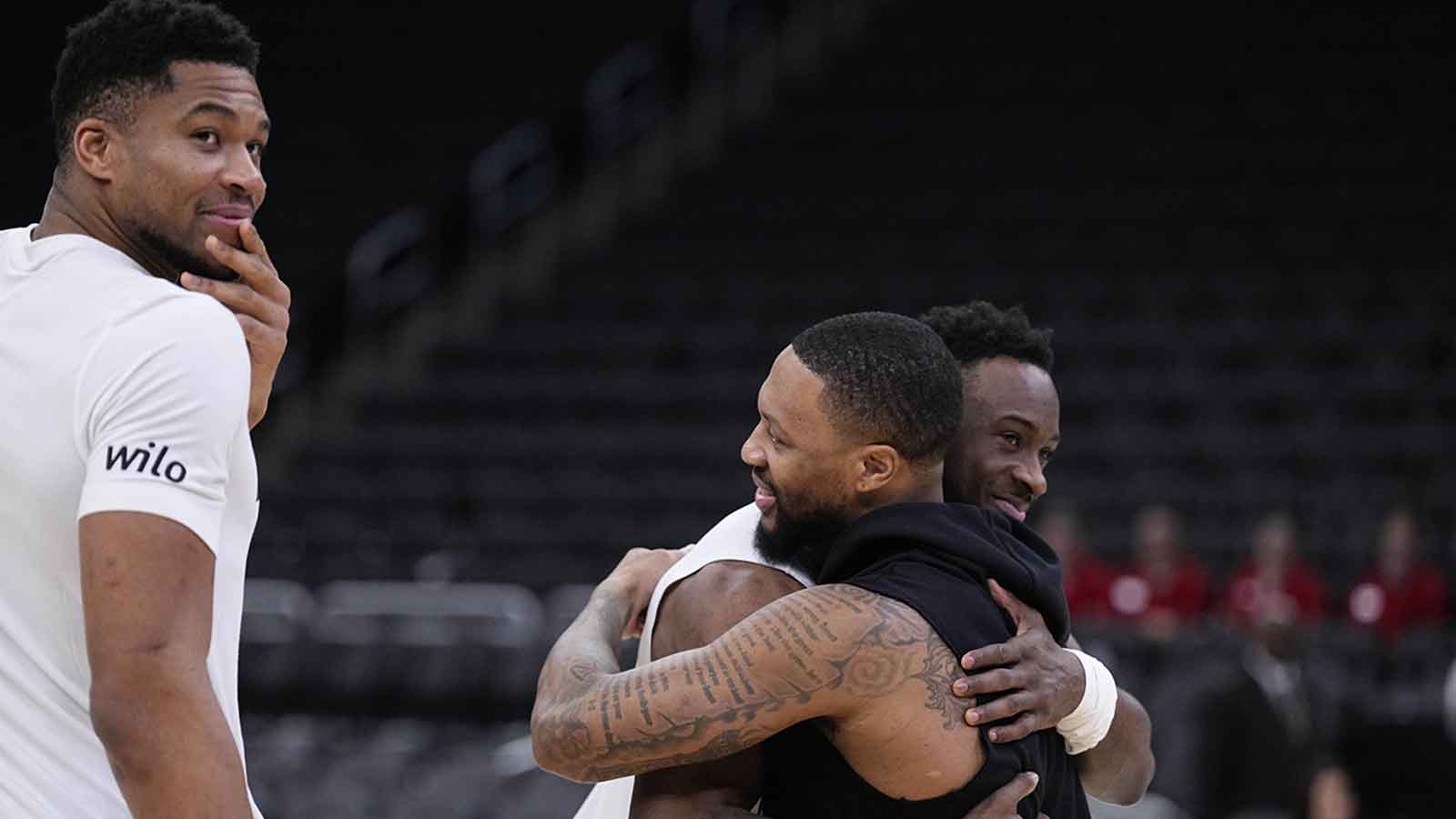 Portland Trail Blazers and former Milwaukee Bucks guard Damian Lilliard (0), right talks gets a hug from Milwaukee Bucks forward Thannasis Antetokounmpo (43) as Milwaukee Bucks forward Giannis Antetokounmpo (34) looks on prior to their game at Fiserv Forum.