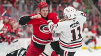 Carolina Hurricanes defenseman Alexander Nikishin (21) and Chicago Blackhawks center Oliver Moore (11) fight during the second period at Lenovo Center.