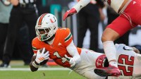 Miami Hurricanes wide receiver Joshisa Trader (1) carries the football against NC State Wolfpack defensive back Jackson Vick (22) during the second quarter at Hard Rock Stadium.