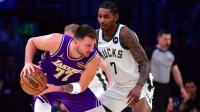 Los Angeles Lakers guard Luka Doncic (77) moves the ball against Milwaukee Bucks guard Kevin Porter Jr. (7) during the first half at Crypto.com Arena.