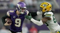Minnesota Vikings quarterback J.J. McCarthy (9) stiff-arms Green Bay Packers linebacker Ty'Ron Hopper (59) after a seven yard run during the first quarter of their game.
