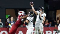 Jacksonville Jaguars quarterback Trevor Lawrence (16) throws a pass as offensive lineman Cole Van Lanen (70) blocks Arizona Cardinals linebacker Zaven Collins (25) at State Farm Stadium.