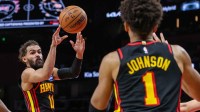 Atlanta Hawks guard Trae Young (11) makes a pass to forward Jalen Johnson (1) against the Miami Heat during the fourth quarter at State Farm Arena.