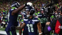 Seattle Seahawks wide receiver Jaxon Smith-Njigba (11) reacts with teammates after catching a touchdown pass against the San Francisco 49ers during the first half in an NFC Divisional Round game at Lumen Field.