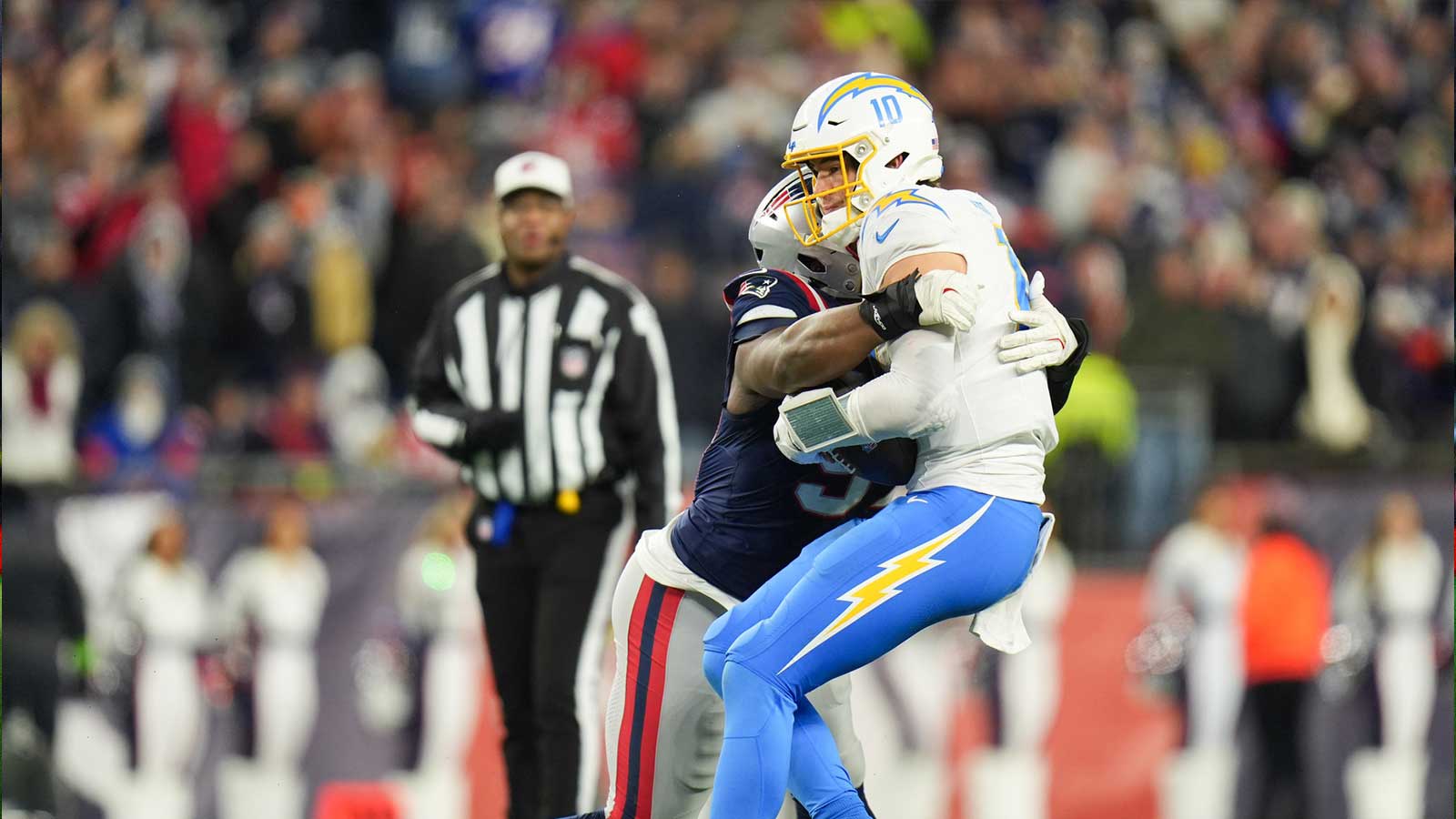 New England Patriots defensive end Milton Williams (97) sacks Los Angeles Chargers quarterback Justin Herbert (10) during the fourth quarter in an AFC Wild Card Round game at Gillette Stadium. 