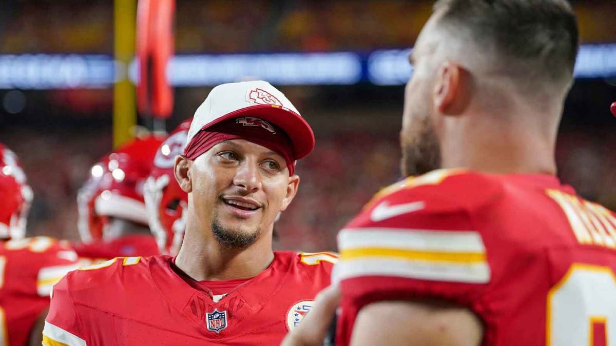 Kansas City Chiefs quarterback Patrick Mahomes (15) laughs with tight end Travis Kelce (87) on the sidelines against the Chicago Bears during the game at GEHA Field at Arrowhead Stadium.