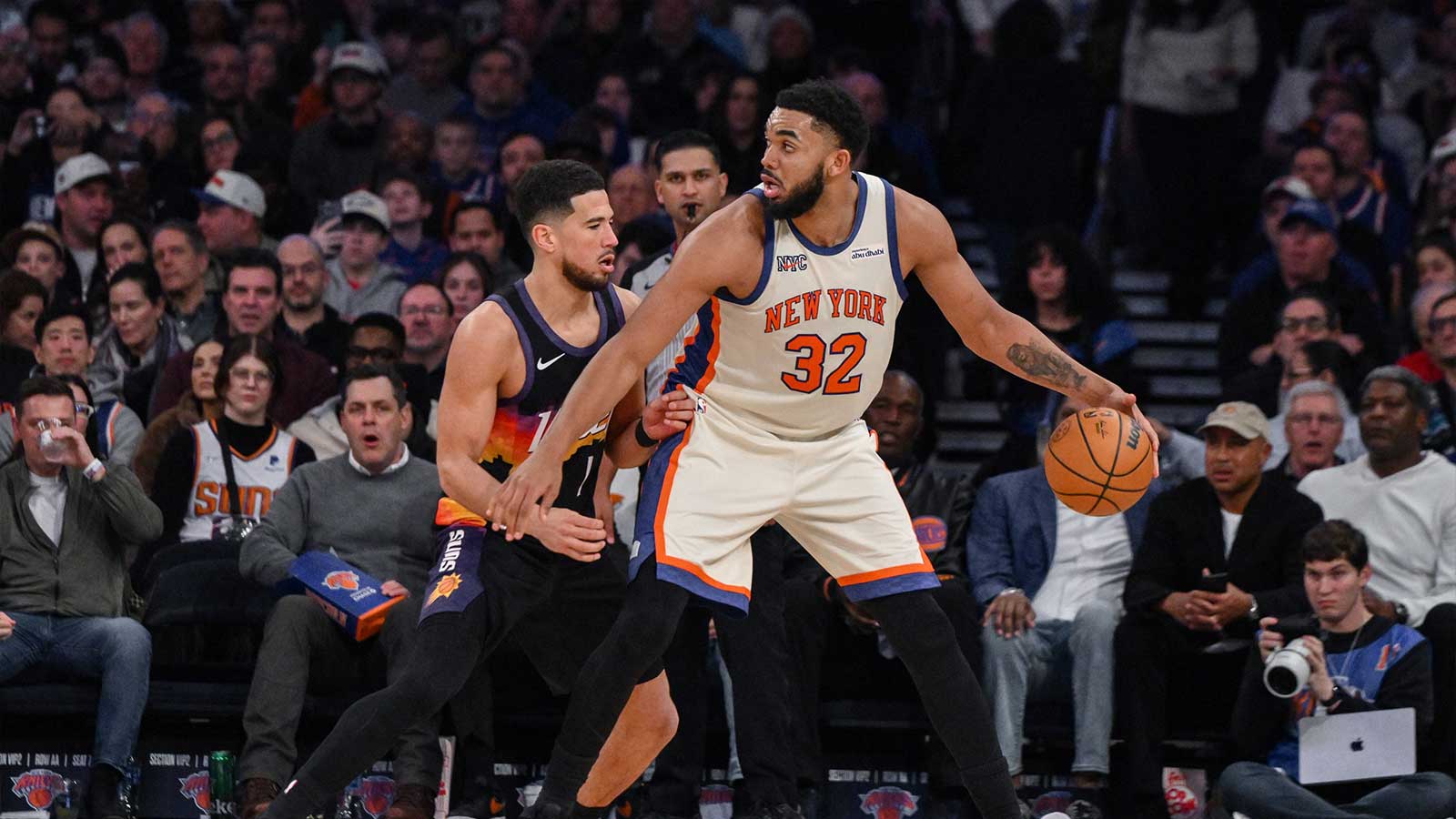 New York Knicks center/forward Karl-Anthony Towns (32) posts up against Phoenix Suns guard Devin Booker (1) during the second half at Madison Square Garden. 