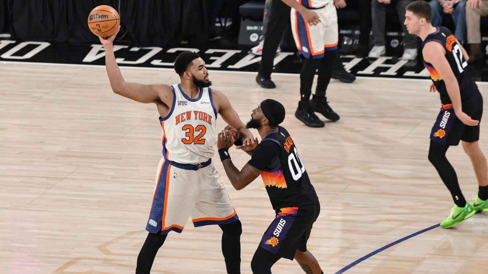 New York Knicks center Karl-Anthony Towns (32) looks to pass the ball as Phoenix Suns forward Royce O'Neale (00) defends during the first half at Madison Square Garden.