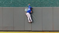 Toronto Blue Jays outfielder Daulton Varsho (5) reaches for a home run by Kansas City Royals shortstop Bobby Witt Jr. (7) during the fourth inning at Kauffman Stadium.