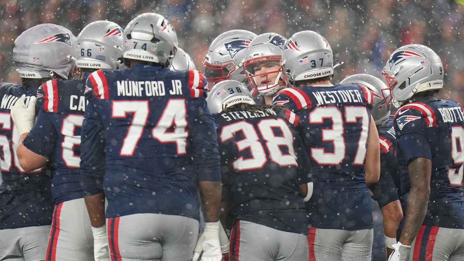 New England Patriots offense gathers around quarterback Drake Maye (10) in the fourth quarter against the Houston Texans in an AFC Divisional Round game at Gillette Stadium.