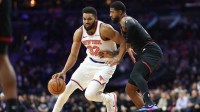 New York Knicks center Karl-Anthony Towns (32) drives against Philadelphia 76ers forward Paul George (8) during the first quarter at Xfinity Mobile Arena.