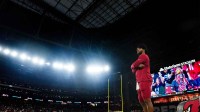 Cardinals quarterback Kyler Murray gets wired up on the sidelines during a preseason game against the Raiders at State Farm Stadium in Glendale on Aug. 23, 2025.
