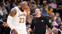 Lakers forward LeBron James (23) walks back on the court in front of head coach JJ Redick during the second quarter against the Dallas Mavericks at the American Airlines Center with Rashad McCants in the background