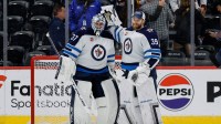 Winnipeg Jets goaltender Connor Hellebuyck (37) reacts with goaltender Laurent Brossoit (39) after the game against the Colorado Avalanche at Ball Arena.