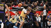 Los Angeles Lakers forward LeBron James (23) passes the ball past Washington Wizards forward Kyshawn George (18) during the first half at Capital One Arena.