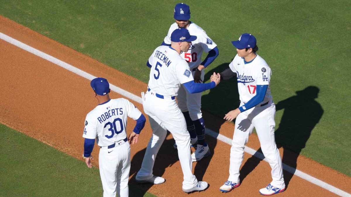 Los Angeles Dodgers manager Dave Roberts (30) interacts with first baseman Freddie Freeman (5), shortstop Mookie Betts (50) and two-way player Shohei Ohtani (17) before game three of the NLCS round for the 2025 MLB playoffs against the Milwaukee Brewers.