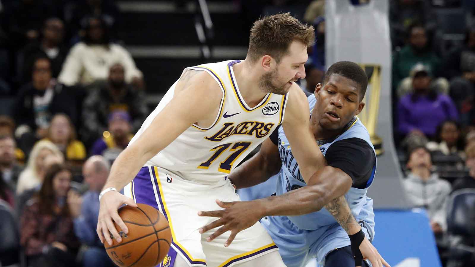 Los Angeles Lakers guard Luka Doncic (77) dribbles as Memphis Grizzlies forward Cedric Coward (23) defends during the fourth quarter at FedExForum.