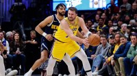 Los Angeles Lakers guard Luka Doncic (77) controls the ball under pressure from Denver Nuggets guard Jamal Murray (27) in the first quarter at Ball Arena.