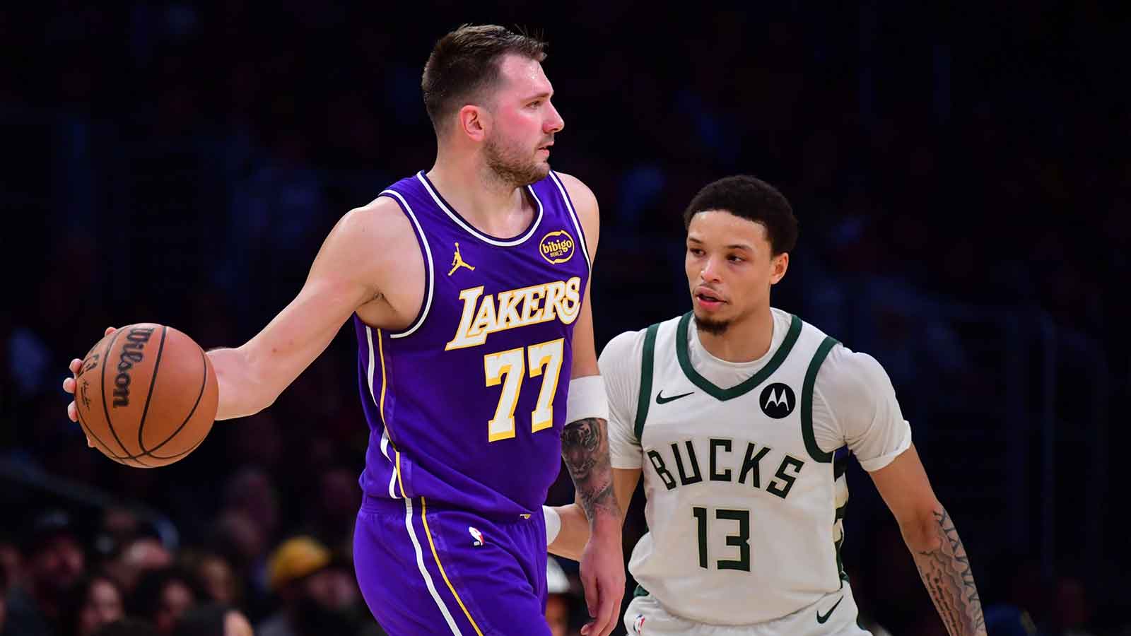 Los Angeles Lakers guard Luka Doncic (77) moves the ball against Milwaukee Bucks guard Ryan Rollins (13) during the first half at Crypto.com Arena. 