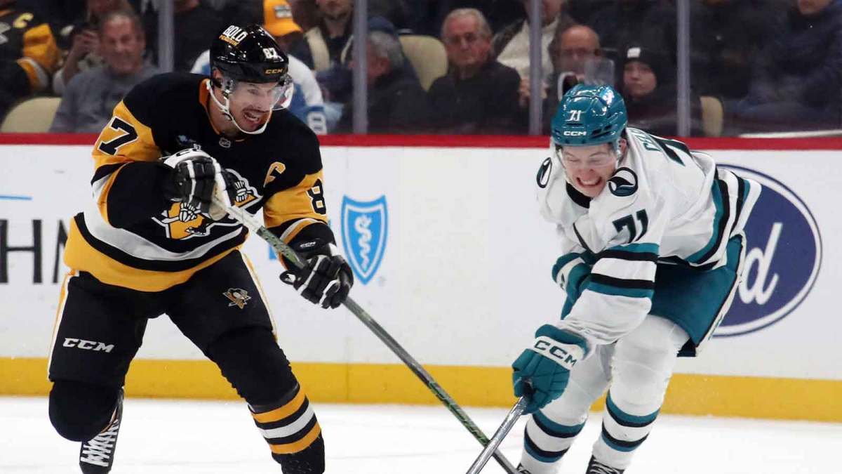 Pittsburgh Penguins center Sidney Crosby (87) and San Jose Sharks center Macklin Celebrini (71) battle to control the puck during the third period at PPG Paints Arena.
