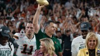 Miami Hurricanes head coach Mario Cristobal holds up the trophy after winning the CFP Fiesta Bowl against Ole Miss at the State Farm Stadium, in Glendale, Ariz., on Thursday, Jan. 8, 2026.