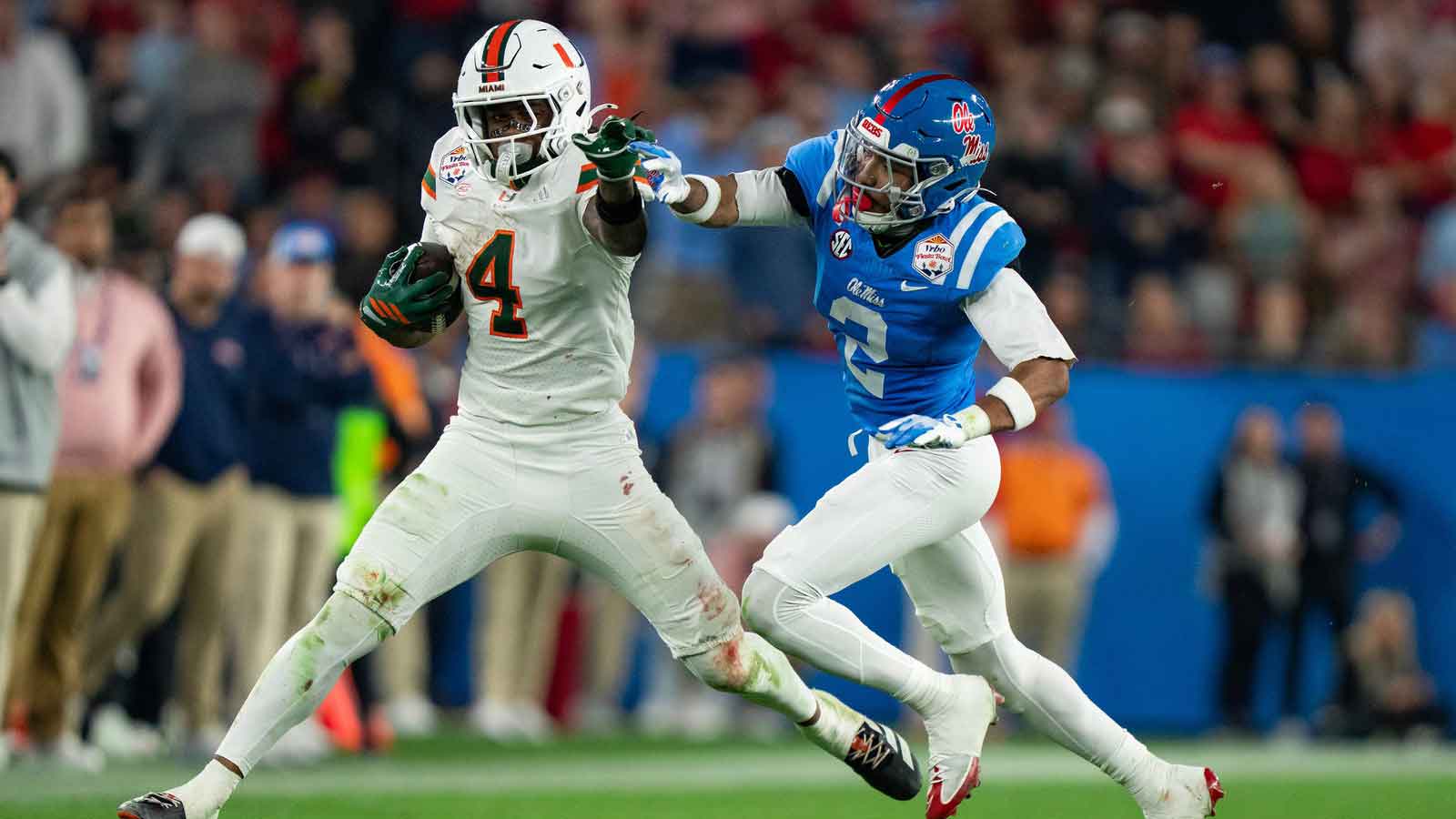 Miami Hurricanes running back Mark Fletcher Jr. (4) runs the ball as Ole Miss cornerback Jaylon Braxton (2) tries to tackle him during the CFP Fiesta Bowl at the State Farm Stadium, in Glendale, Ariz., on Thursday, Jan. 8, 2026.