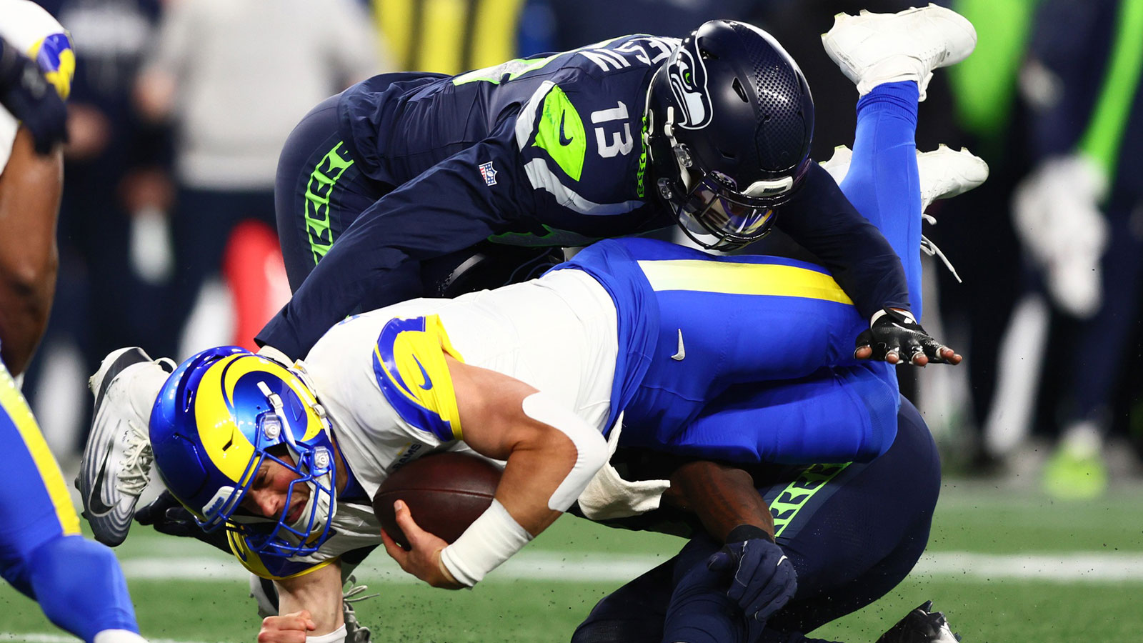 Los Angeles Rams quarterback Matthew Stafford (9) dives for a first down against Seattle Seahawks linebacker Ernest Jones IV (13) during the second half in the 2026 NFC Championship Game at Lumen Field.
