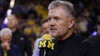 Michigan Wolverines football head coach Kyle Whittingham speaks to the crowd during a time out in the first half against the Southern California Trojans at Crisler Center.