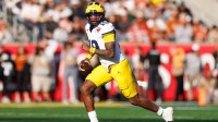Michigan Wolverines quarterback Bryce Underwood (19) looks to throw on the run against the Texas Longhorns during the first half at Camping World Stadium.