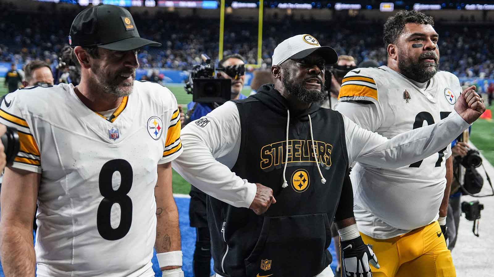 Pittsburgh Steelers coach Mike Tomlin celebrates as he walks off the field with quarterback Aaron Rodgers and defensive tackle Cameron Heyward after a 29-24 win over the Detroit Lions at Ford Field in Detroit on Sunday, Dec. 21, 2025.