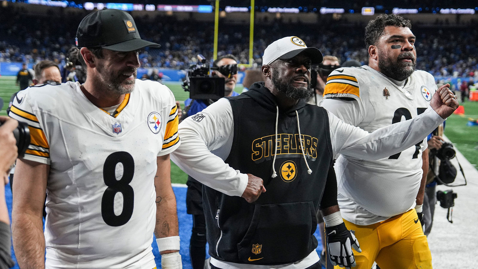 Pittsburgh Steelers coach Mike Tomlin celebrates as he walks off the field with quarterback Aaron Rodgers and defensive tackle Cameron Heyward after a 29-24 win over the Detroit Lions at Ford Field in Detroit on Sunday, Dec. 21, 2025.