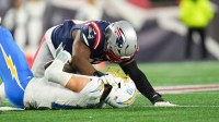 New England Patriots defensive end Milton Williams (97) sacks Los Angeles Chargers quarterback Justin Herbert (10) during the fourth quarter in an AFC Wild Card Round game at Gillette Stadium.