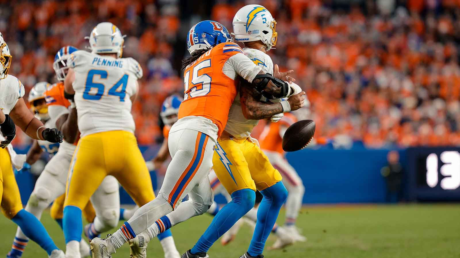 Denver Broncos linebacker Nik Bonitto (15) strip sacks Los Angeles Chargers quarterback Trey Lance (5) in the third fourth at Empower Field at Mile High.