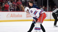 New York Rangers center Noah Laba (42) skates of ice with a trainer after an injury during the second period against the Washington Capitals at Capital One Arena.