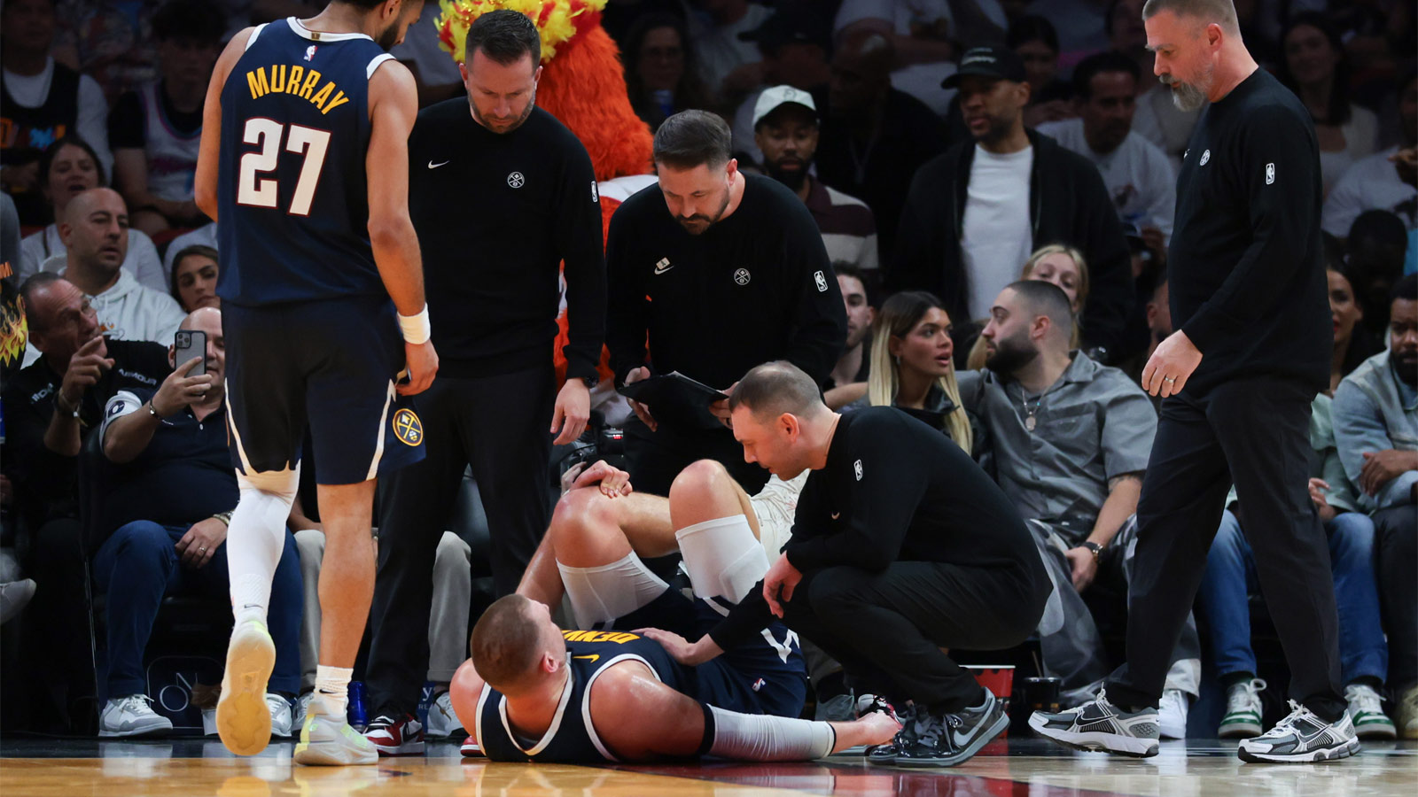 Denver Nuggets center Nikola Jokic (15) is looked at by trainers after an injury against the Miami Heat during the second quarter at Kaseya Center.
