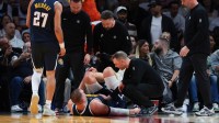 Denver Nuggets center Nikola Jokic (15) is looked at by trainers after an injury against the Miami Heat during the second quarter at Kaseya Center.