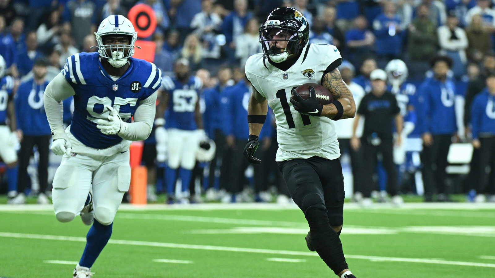 Jacksonville Jaguars wide receiver Parker Washington (11) runs against Indianapolis Colts defensive tackle Adetomiwa Adebawore (95) during the second half at Lucas Oil Stadium.