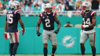 New England Patriots linebacker Harold Landry III (2) celebrates with linebacker Marte Mapu (15) and linebacker K'Lavon Chaisson (44) after sacking Miami Dolphins quarterback Tua Tagovailoa (not pictured) during the fourth quarter at Hard Rock Stadium.