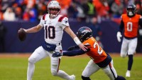 New England Patriots quarterback Drake Maye (10) rushes the ball against Denver Broncos safety Devon Key (26) during the first half in the 2026 AFC Championship Game at Empower Field at Mile High