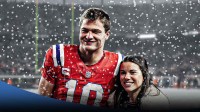 New England Patriots quarterback Drake Maye and his wife, Ann Michael Maye, with snow around them and Denver Broncos stadium in background.