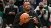 Former Boston Celtics player Paul Pierce carries the game ball before a game against the Toronto Raptors at the TD Garden with the 3-point contest logo in the background