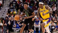 Pelicans center Derik Queen (22) dribbles against Los Angeles Lakers forward Jarred Vanderbilt (2) during the second half at Smoothie King Center with LeBron James and Victor Wembanyama in the background