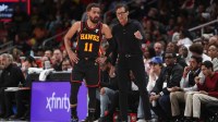 Atlanta Hawks guard Trae Young (11) and head coach Quin Snyder on the bench against the Charlotte Hornets during the second half at State Farm Arena.