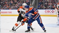Edmonton Oilers right winger Quinn Hutson (23) and Philadelphia Flyers defenseman Nick Seeler (24) are seen out on the ice during the first period at Rogers Place.