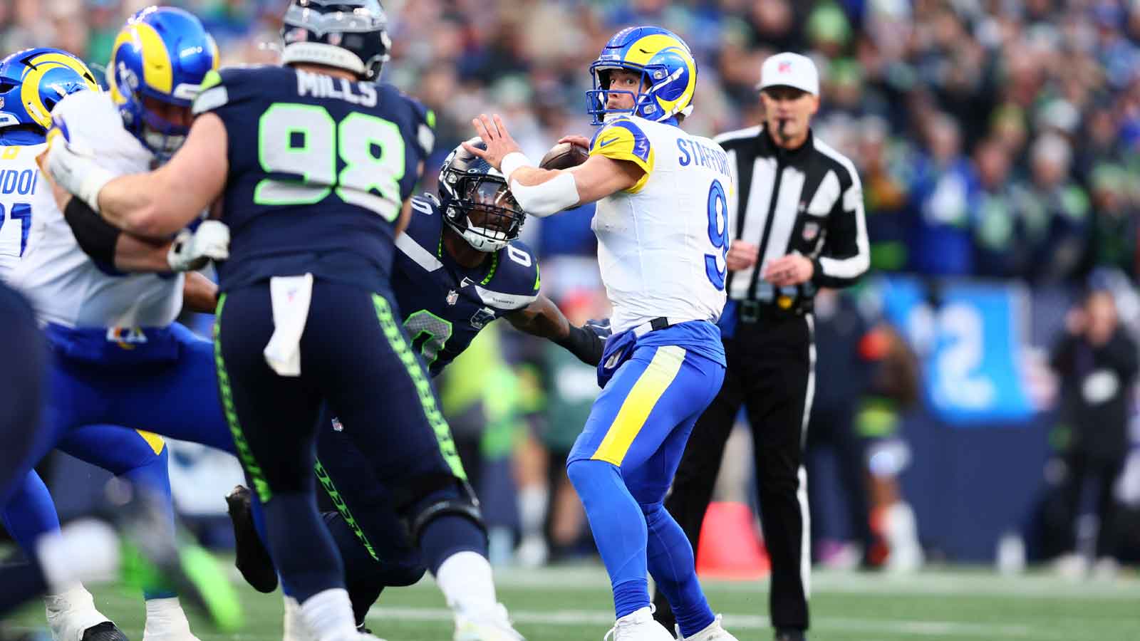 Los Angeles Rams quarterback Matthew Stafford (9) passes against Seattle Seahawks defensive end DeMarcus Lawrence (0) during the first half in the 2026 NFC Championship Game at Lumen Field.