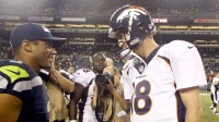 Seattle Seahawks quarterback Russell Wilson (3) and Denver Broncos quarterback Peyton Manning (18) speak following a 40-10 preseason victory by the Seahawks at CenturyLink Field.