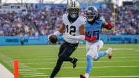 Dec 28, 2025; Nashville, Tennessee, USA; New Orleans Saints wide receiver Chris Olave (12) runs in a touchdown in front of Tennessee Titans cornerback Kemon Hall (40) during the third quarter at Nissan Stadium.